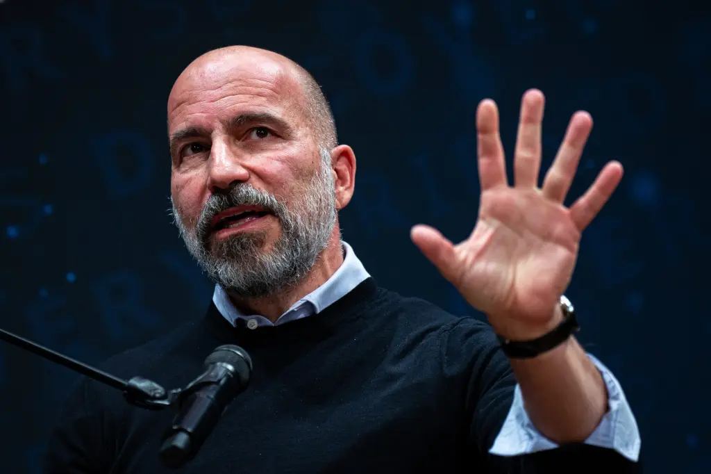 Uber CEO Dara Khosrowshahi speaking with his hand raised